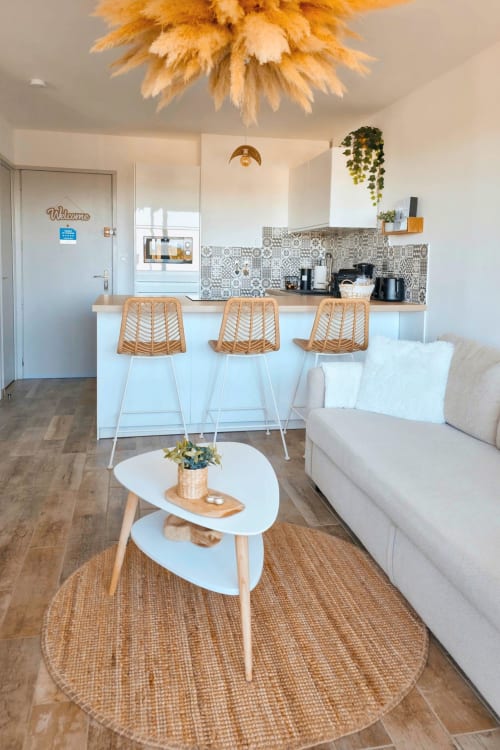 Appartement moderne au Sable & Pampas B&B à Carnon-Plage avec cuisine, tabourets en rotin et séjour lumineux