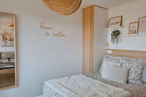Chambre moderne au Sable & Pampas BnB à Carnon-Plage avec accents bois, literie blanche et décoration murale 'Time to relax'