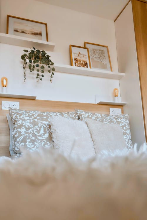 Chambre douillette au Sable & Pampas à Carnon-Plage avec tête de lit en bois, coussins décor et tableau mural encadré