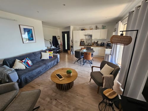 Espace de vie ouvert de la villa Altezza à Brando avec cuisine moderne, table à manger, canapé et baies vitrées avec vue sur la mer
