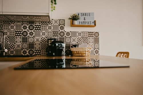 Plan de travail Sable & Pampas avec carrelage motifs, cafetière noire, panier tressé et plante à Carnon-Plage