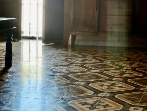 Historic geometric floor tiles in Lecce's HABITARE luxury B&B, with natural light from tall windows illuminating the elegant