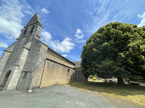 Chapelle en pierre historique avec clocher à La Closerie Des Arts à Gabillou, France, entourée de verdure luxuriante