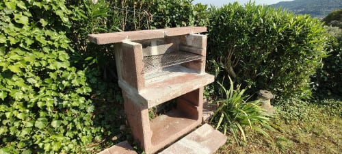 Rustico forno per pizza in mattoni nel giardino dell'hotel Prince Garda a Salò, circondato da siepi verdi