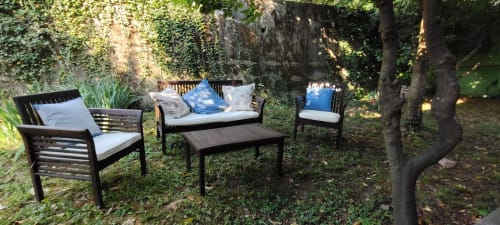 Area lounge ombreggiata dell'hotel Prince Garda di Salò con mobili neri e cuscini bianchi