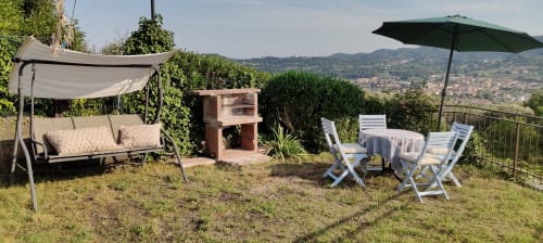 Terrazza del giardino Prince Garda a Salò con altalena, lettini, ombrellone e vista panoramica sulle colline