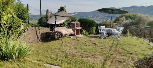 Terrazza del giardino Prince Garda a Salò con altalena lounge, ombrelloni e vista sulle montagne