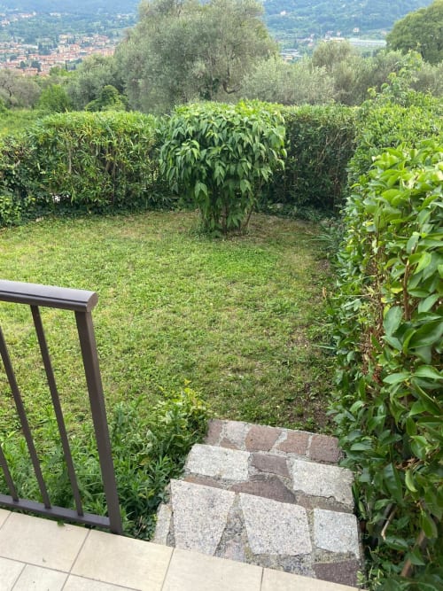 Scalinata del giardino dell'Hotel Prince Garda a Salò con siepi curate e vista sulla campagna italiana