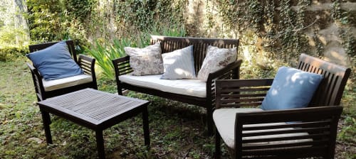 Arredamento in legno nero nel giardino Prince Garda di Salò con cuscini blu e decorativi