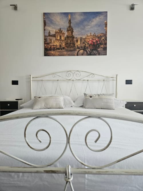 Camera elegante al B&B Hélios a Nardò con letto in ferro battuto ornamentale, biancheria bianca e opere d'arte europea