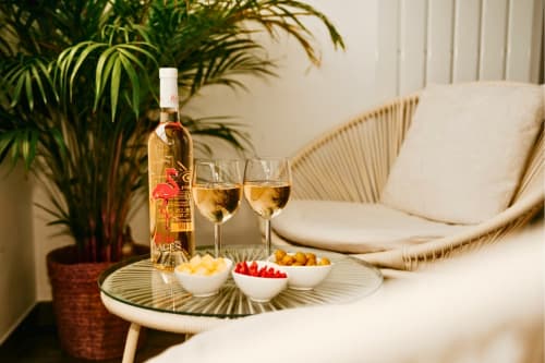 Wine and appetizers at Sable & Pampas in Carnon-Plage with rosé, cheese, berries, and coastal modern décor.