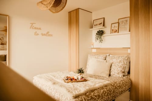 Cozy bedroom at Sable & Pampas B&B in Carnon-Plage with neutral tones, wooden accents, and breakfast tray on bed