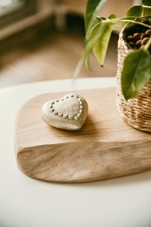 Heart-shaped ceramic decoration on wooden table with potted plant at Sable & Pampas, Carnon-Plage