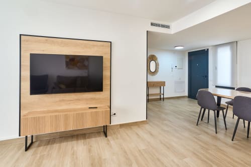 Sala de estar moderna en Tr3sor Homes Calella con TV de pantalla plana, comedor, pisos de madera y diseño contemporáneo