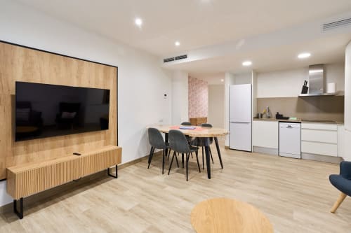 Moderno apartamento de 2 dormitorios en Tr3sor Homes Calella con salón abierto, comedor, cocina, zona TV y muebles de madera