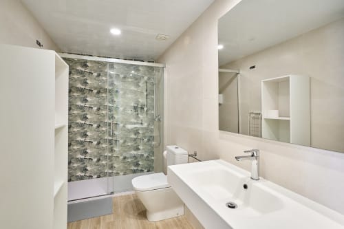 Baño moderno en apartamento Tr3sor 13, Calella con ducha, inodoro, lavabo y espejo