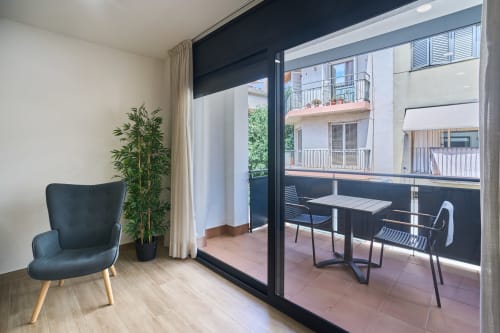 Interior moderno de apartamento con puerta-balcón azul oscuro, área de descanso y vistas a la terraza en Calella