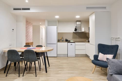Moderno apartamento en Calella con cocina abierta, mesa de comedor y zona de estar en Tr3sor Homes