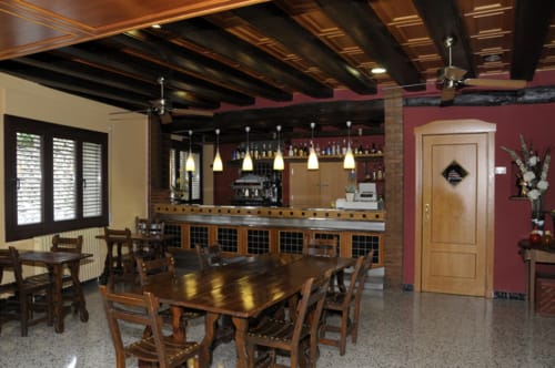 Comedor del bar Restaurante Grau en Tarragona con mesas de madera, lámparas colgantes y barra de ladrillo