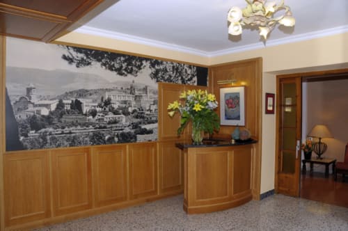 Elegante vestíbulo del hotel en Restaurant Hostal Grau de Tarragona con paneles de madera, recepción y vistas urbanas vintage