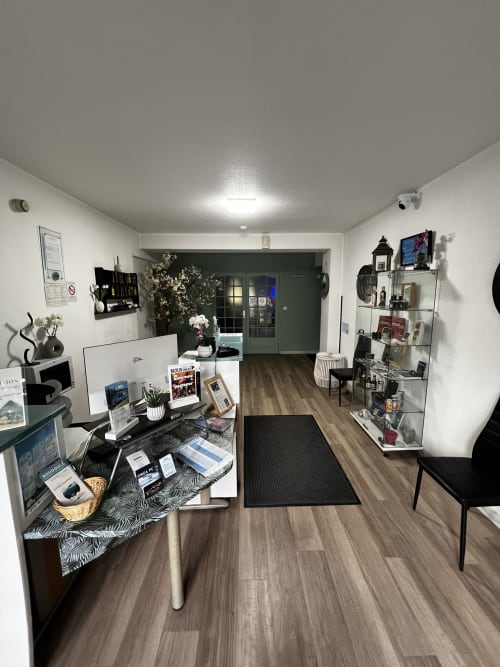 Modern B&B reception area at Hôtel les Alizés in Puget-Théniers with desk, shelving, and welcoming entryway