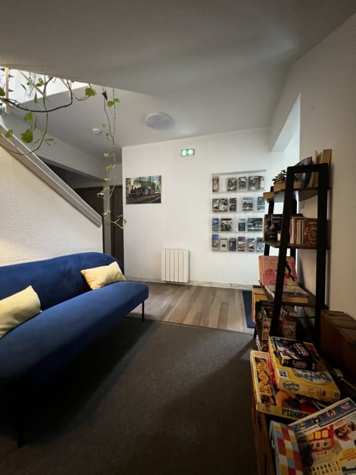 Cozy living area at Hôtel les Alizés with blue sofa, climbing plants, and vintage decor in Puget-Théniers
