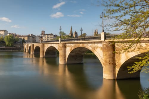 Puente de piedra sobre el río Ebro en Logroño con torres de la catedral y edificios históricos al fondo, vista desde el hotel Muro 13