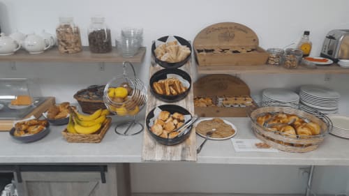 Breakfast buffet display at Hôtel les Alizés with pastries, fresh fruit, cereals, and breads in Puget-Théniers