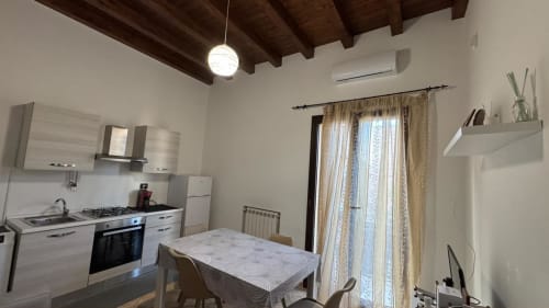 Moderna zona cucina-sala da pranzo dell'appartamento Zza Caterina presso Solunto Home Holiday, Santa Flavia, con tavolo da pranzo e attrezzato