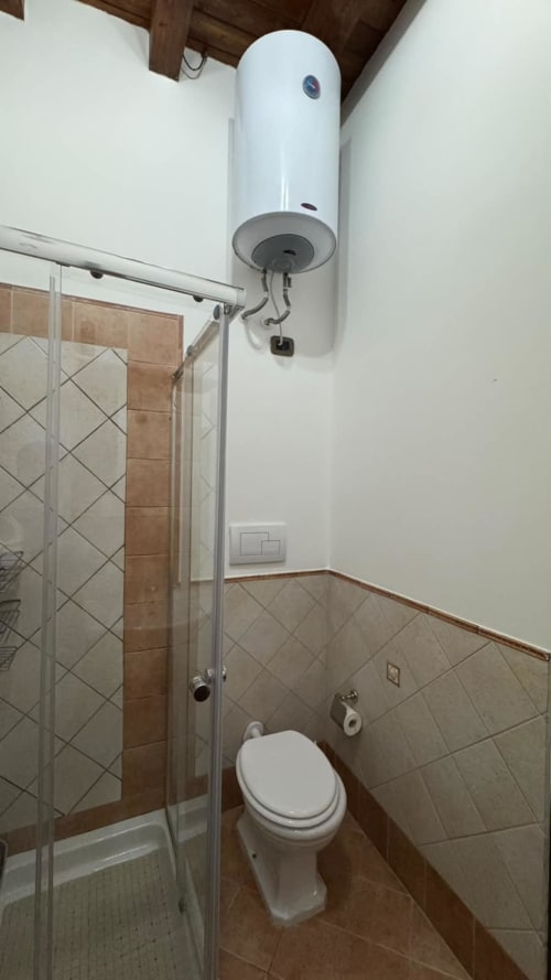 Bagno moderno presso Solunto Home Holiday con doccia, toilette e scaldabagno a parete