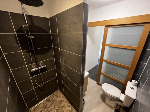 Bagno della Camera Tripla all'Hôtel les Alizés: doccia con piastrelle nere moderne e WC bianchi, Puget-Théniers