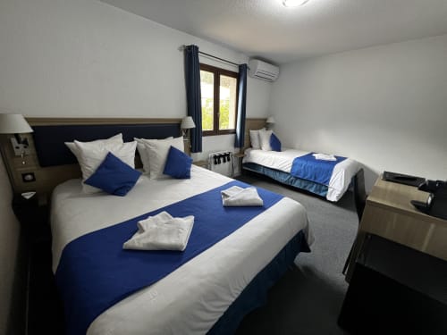 Triple room at Hôtel les Alizés in Puget-Théniers with double and single beds, blue accents, and modern amenities