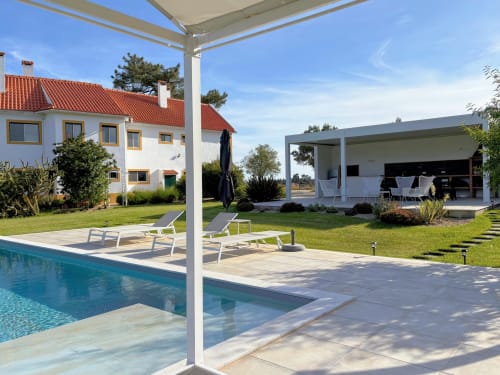 Terraço de piscina de luxo Quinta Vale da Paz em Azambuja com espreguiçadeiras, pérgola moderna e vistas para o campo