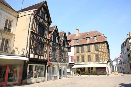 Bâtiments à colombages historiques sur la place d'Escolives-Sainte-Camille près du Domaine des Oiseaux de Passage