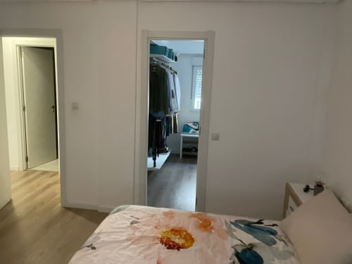 Dormitorio luminoso con ropa de cama floral en Algemesi Home, Valencia, acceso al vestidor y vistas a la ciudad