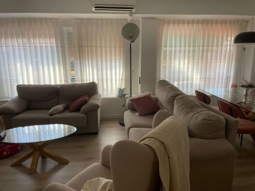 Amplio salón en Algemesi Home Valencia con sofás cómodos, grandes ventanales con vistas a la ciudad e iluminación natural