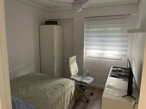Dormitorio moderno con armario, escritorio y vistas a la ciudad en el ático Luminoso de Algemesi, Valencia