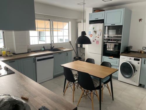Cocina-comedor moderno en apartamento de Algemesi con armarios azul claro, mesa de madera, sillas negras y vistas a la ciudad