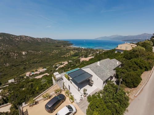 Villa Roya surplombant les eaux turquoise de la Méditerranée à Saint-Florent, Corse, avec architecture moderne et vue sur mer