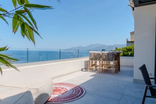 Terrasse panoramique de la Villa Roya à Saint-Florent avec vue sur la mer Méditerranée, espace repas et lounge