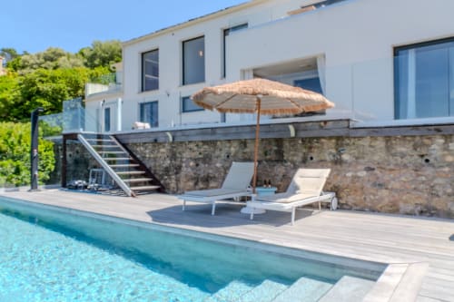 Piscine de luxe Villa Roya avec transats, parasol et architecture moderne à Saint-Florent
