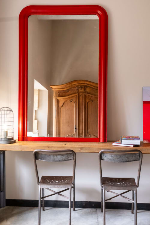 Coiffeuse moderne avec miroir à cadre rouge et chaises métalliques à l'hôtel-boutique Le Jardin Secret à Grignan