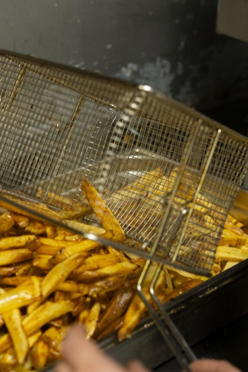 Pommes de terre dorées égouttant dans un panier métallique à l'hôtel BDM, Montastruc-la-Conseillère