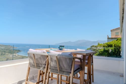 Terrasse de restaurant à La Conciergerie du Cap Corse à Centuri, vue sur la mer Méditerranée et les montagnes