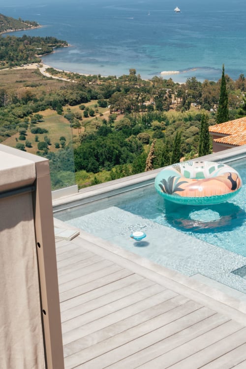 Piscine à débordement Villa Roya avec eau turquoise et flotteur dominant la baie de Saint-Florent et la côte méditerranéenne
