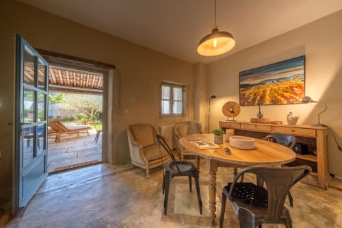Suite élégante au Jardin Secret B&B à Grignan avec portes-fenêtres ouvrant sur le jardin, table ronde et fauteuils