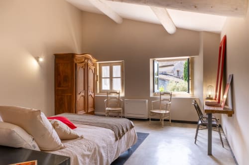 Suite spacieuse l'Olivier au Jardin Secret à Grignan avec lit, coin salon, fenêtres et poutres rustiques