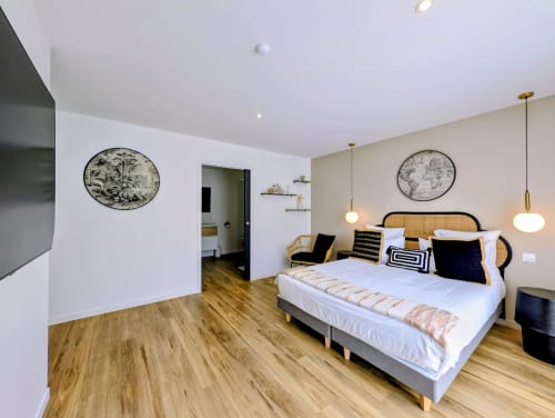 Chambre moderne à La Clairière aux Chênes à Treillières avec lit queen-size, tête de lit en rotin, luminaires suspendus, parquet