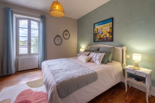 Chambre du Jardin Secret B&B à Grignan avec mur d'accent vert, lit queen-size et vue sur la piscine