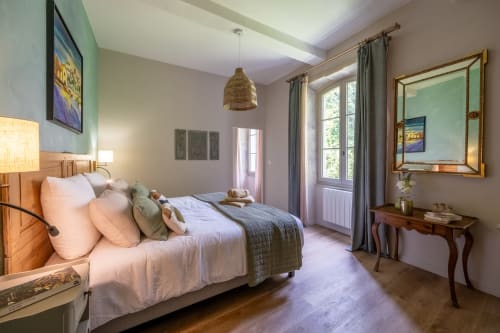 Chambre élégante du Jardin Secret à Grignan avec vue sur la piscine, mobilier en bois et équipements modernes